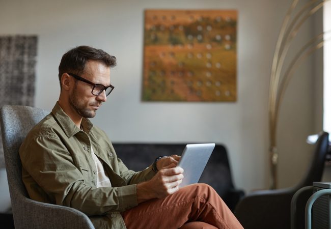 serious-designer-eyeglasses-sitting-sofa-working-online-digital-tablet-modern-office_11zon (1)